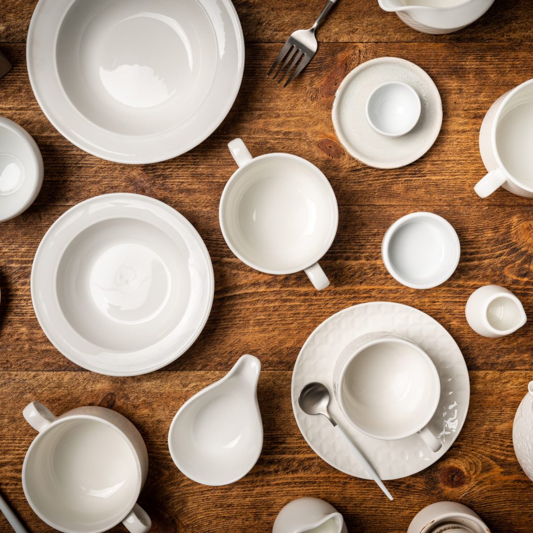 Set of white empty dishes or tableware on wooden background, top view