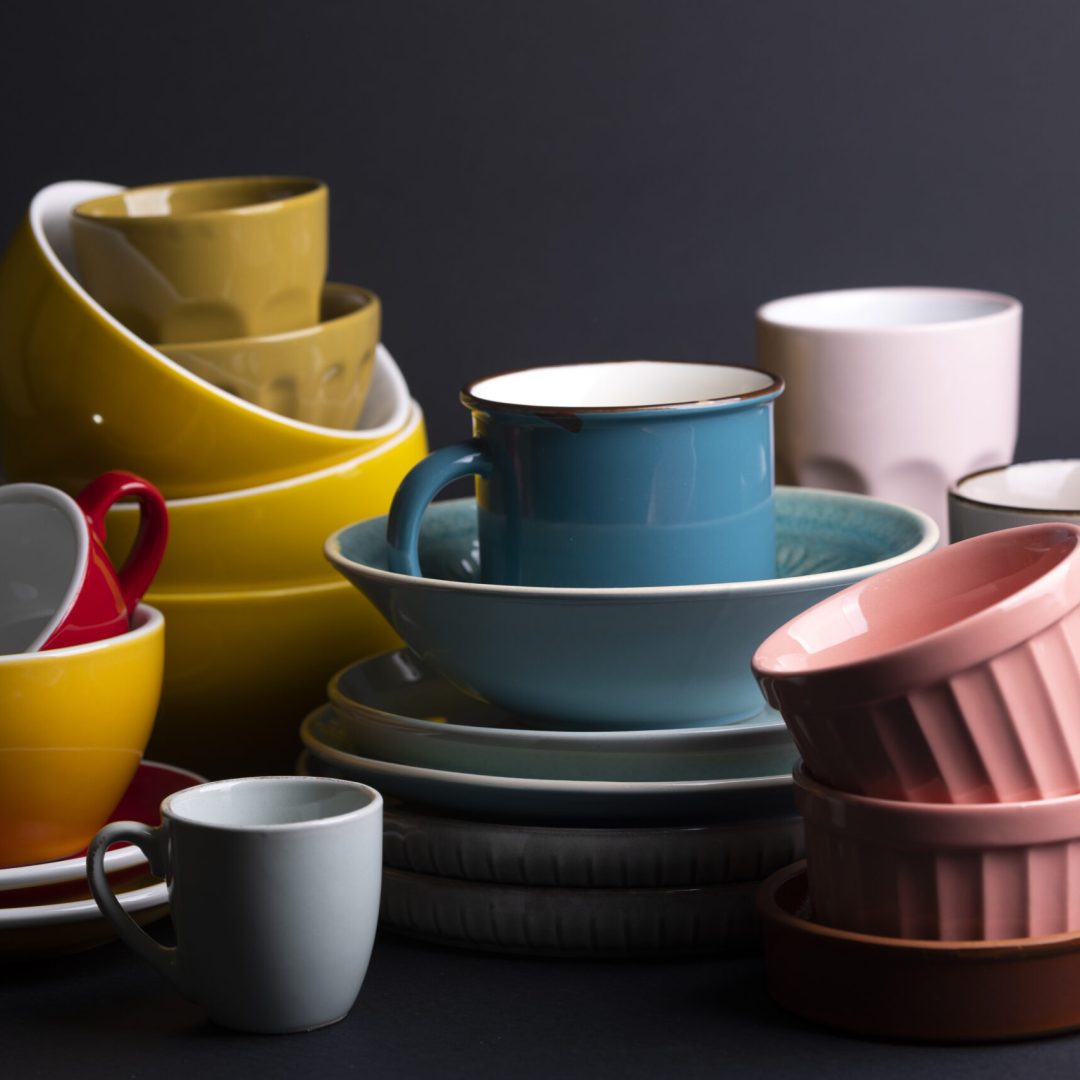 bright ceramics - bowl and cups in colorful colors on a black background