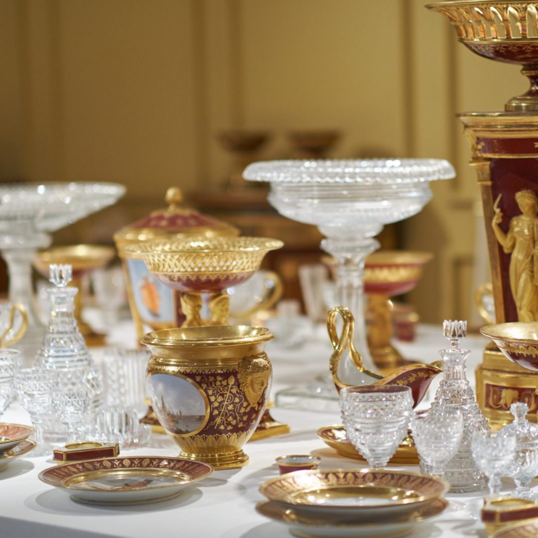 Wedding. Banquet. The chairs and round table for guests, served with cutlery, greenery flowers and crockery and covered with a white tablecloth.